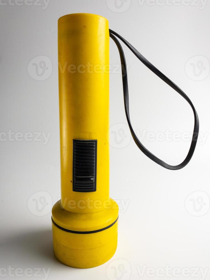 yellow flashlight on white background. copy space. flashlight for blackout and emergency. selected focus photo