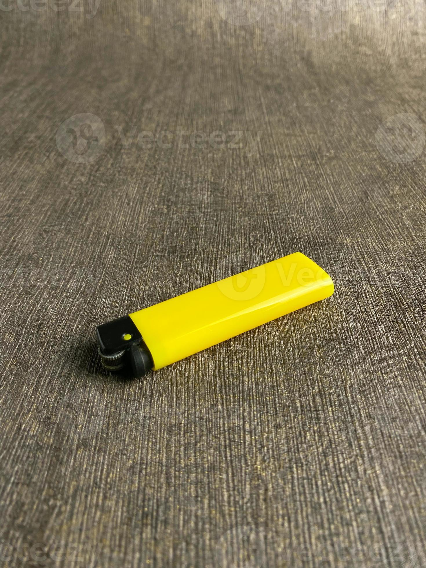yellow lighter isolated on white background. hand tried to lit yellow