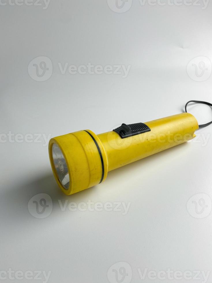 yellow flashlight on white background. copy space. flashlight for blackout and emergency. selected focus photo