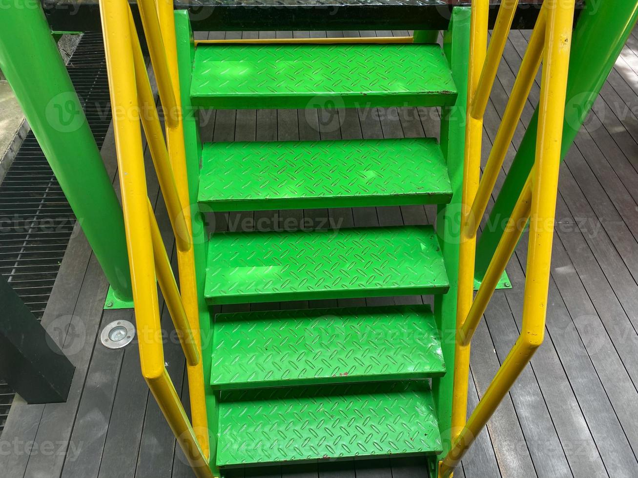 children staircase. green and yellow steel staircase with iron hand railing and mesh. kids stairs design for playground and school. photo