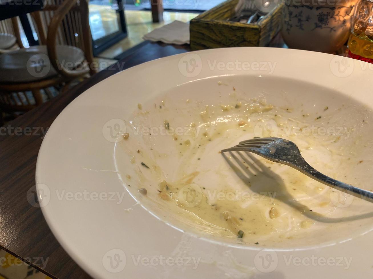 Dirty plate with food leftovers on wooden background, top view photo
