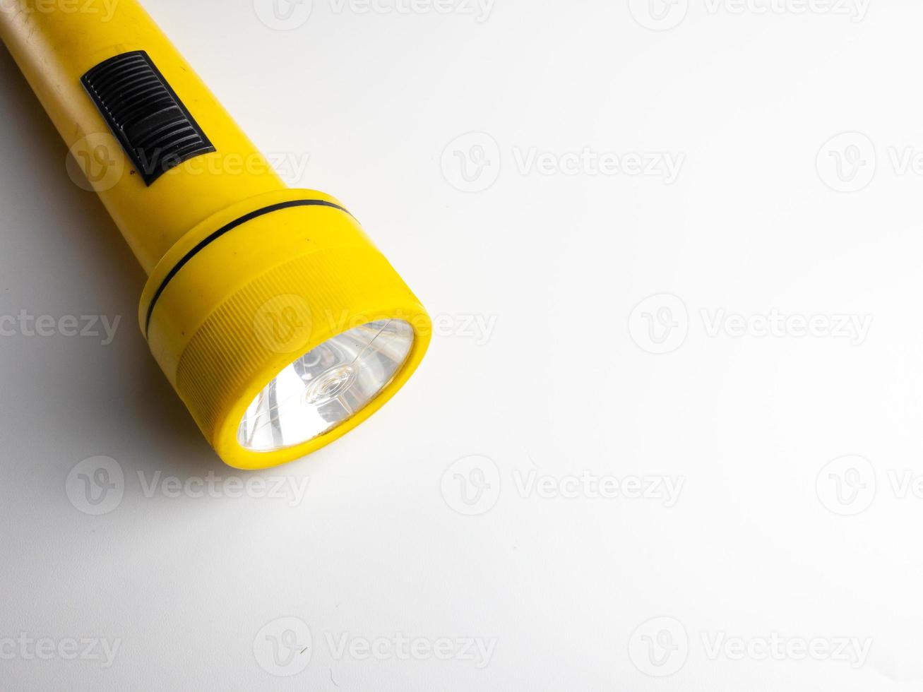 yellow flashlight on white background. copy space. flashlight for blackout and emergency. selected focus photo