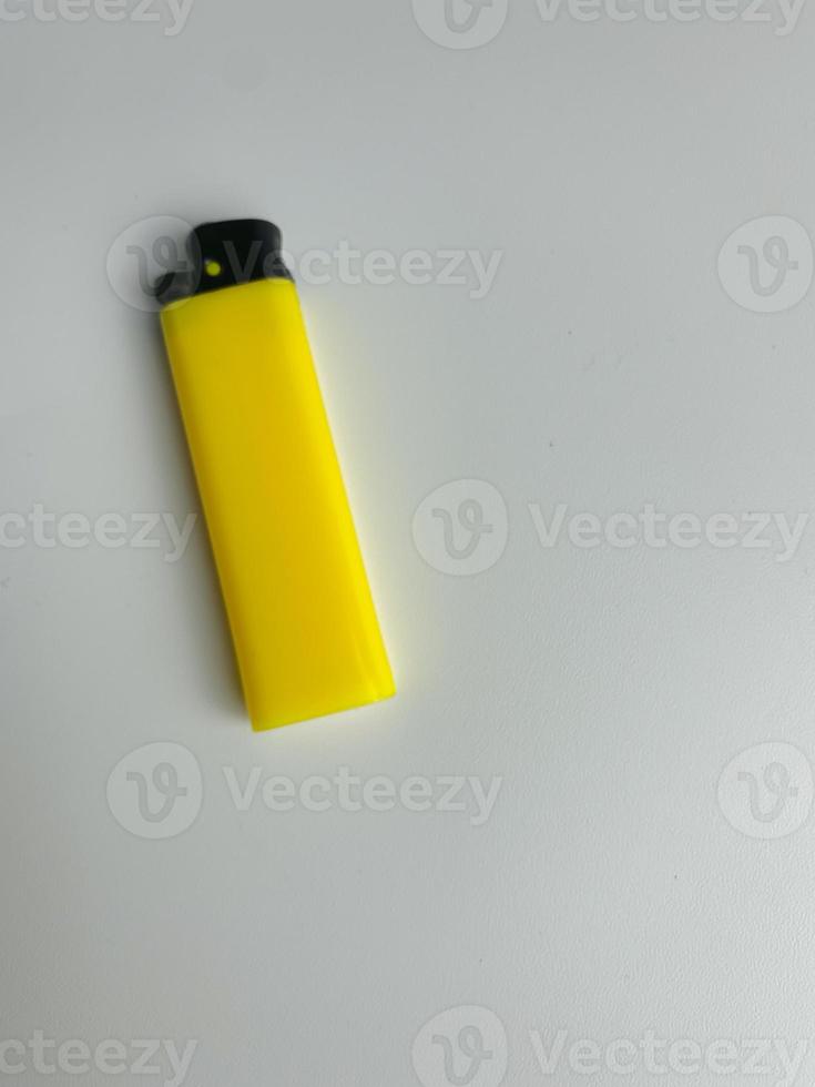 yellow lighter isolated on white background. hand tried to lit yellow lighter. copy space. selected focus photo