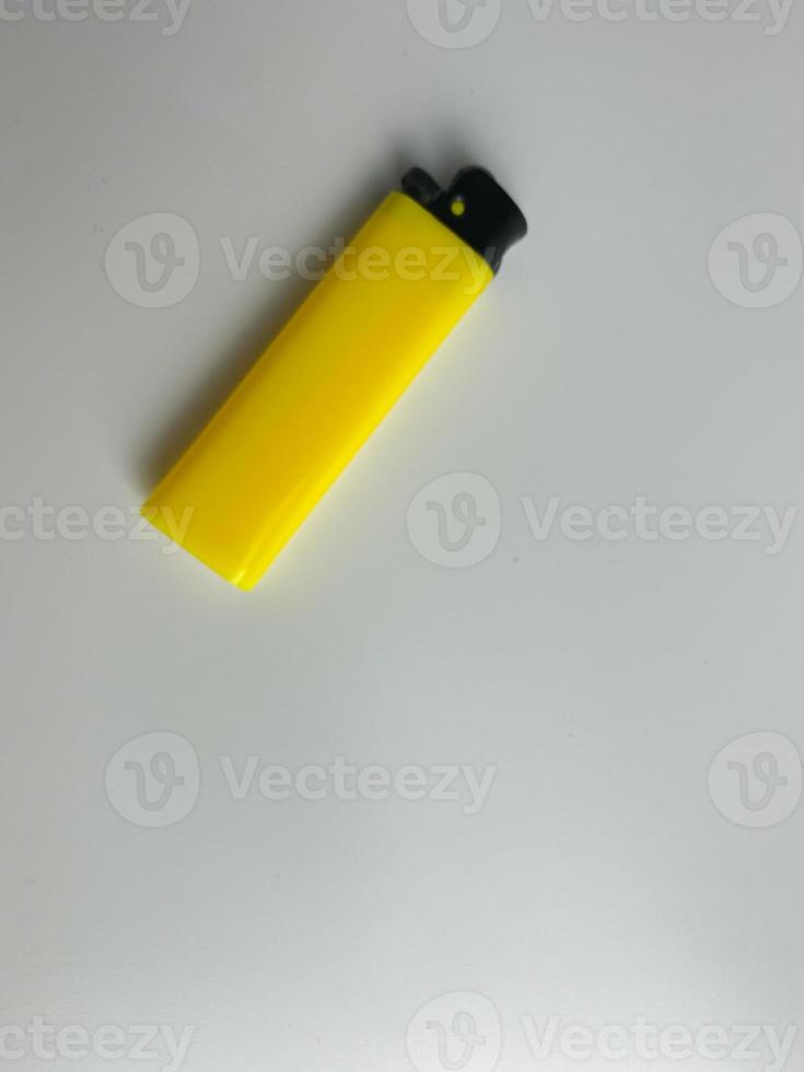 yellow lighter isolated on white background. hand tried to lit yellow lighter. copy space. selected focus photo