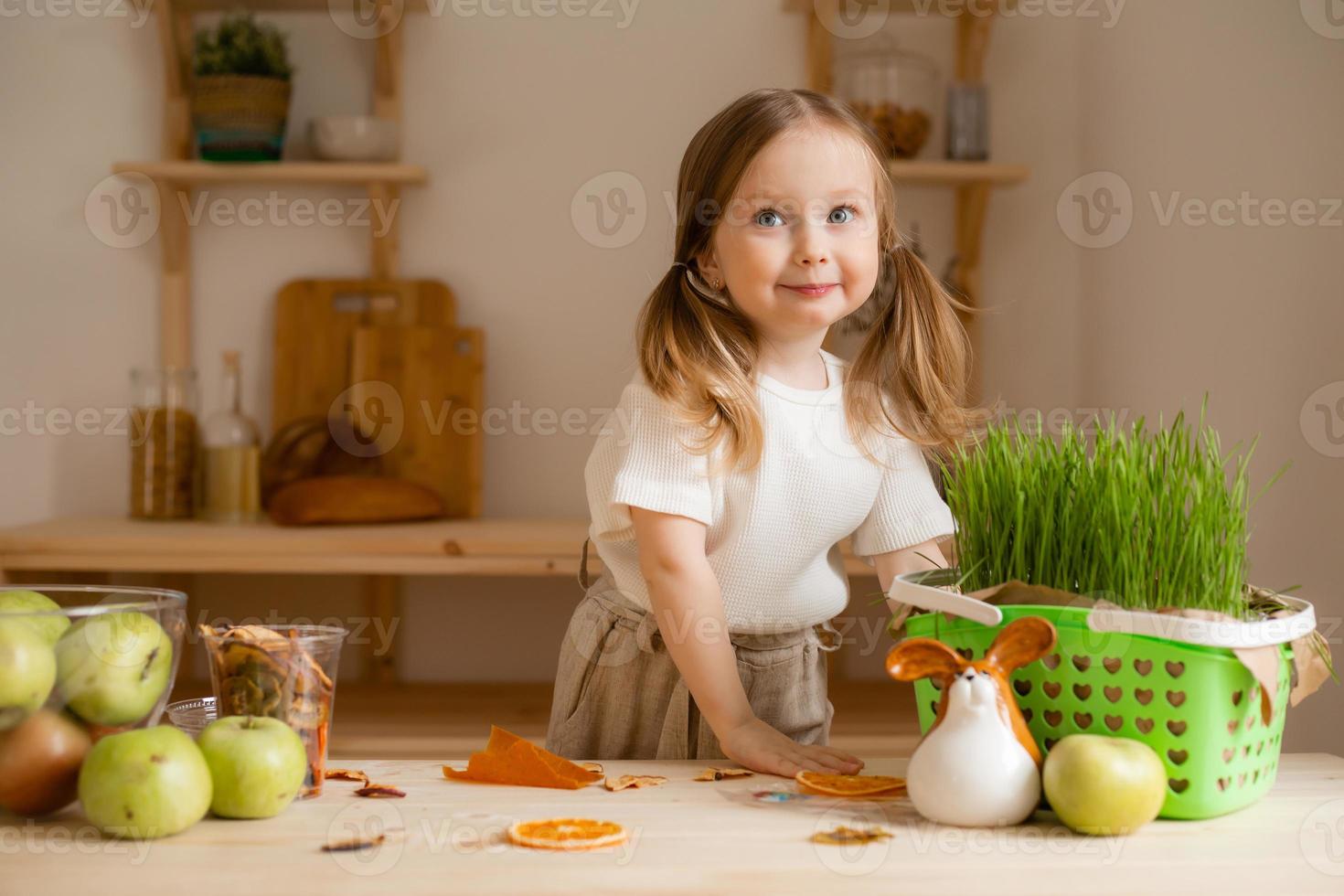 linda pequeño niña come natural pastilla a hogar en un de madera cocina. comida para niños desde natural productos foto