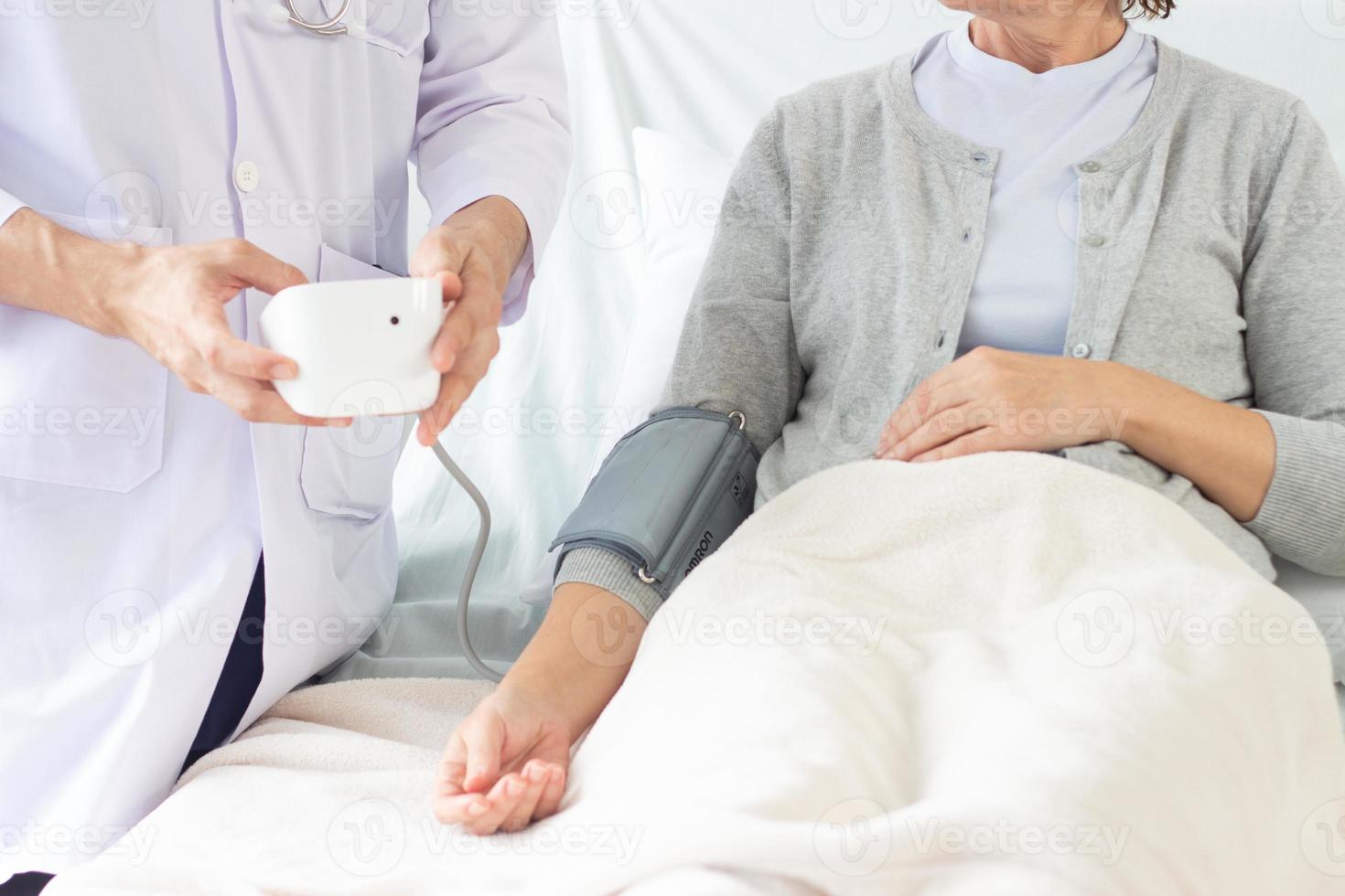 caucásico masculino médico medición sangre presión de hembra paciente en hospital. foto