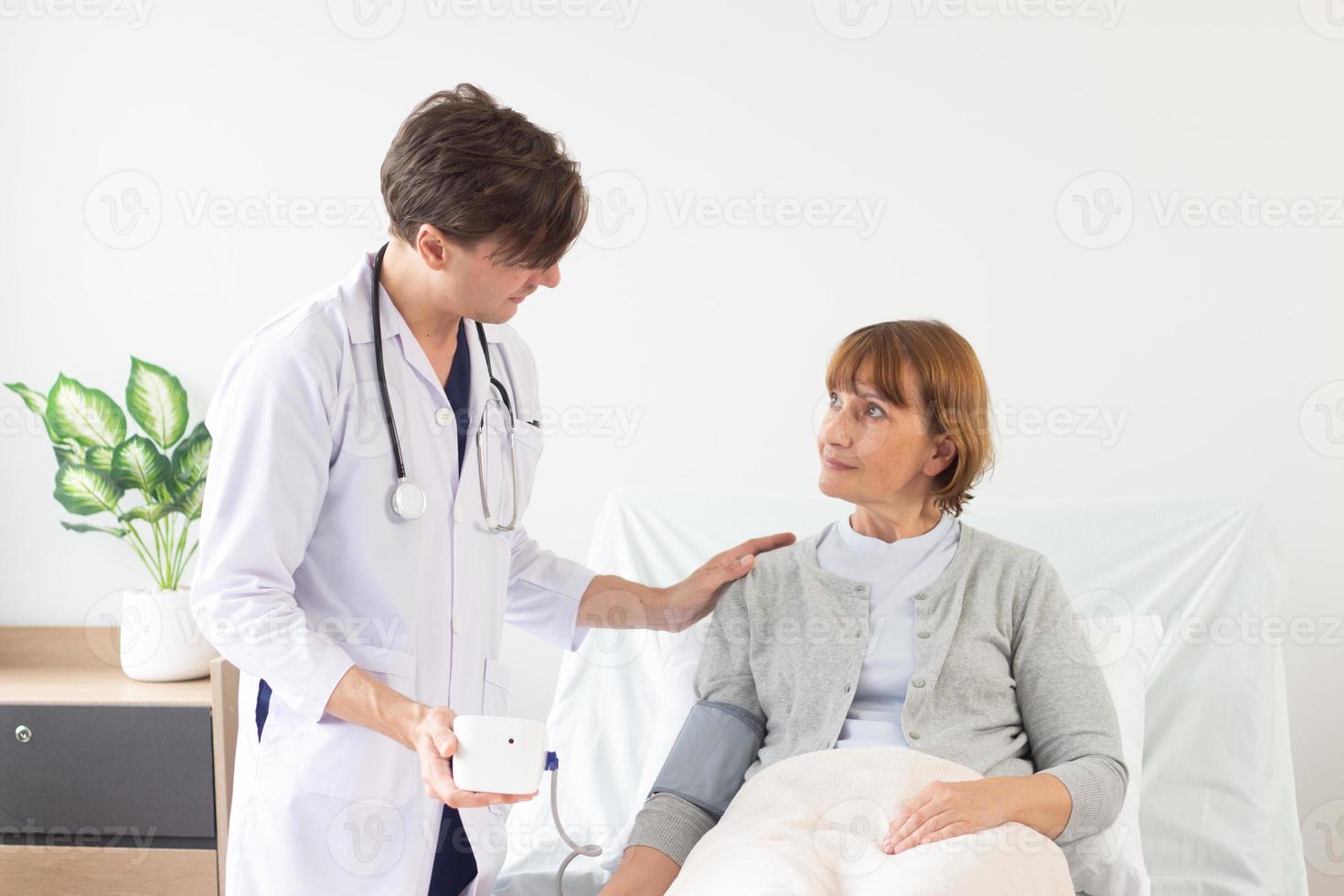 caucásico masculino médico medición sangre presión de hembra paciente en hospital. foto