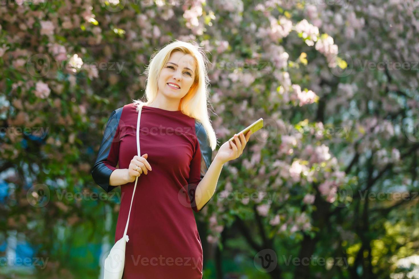 A portrait of a smiling beautiful woman texting with her phone photo