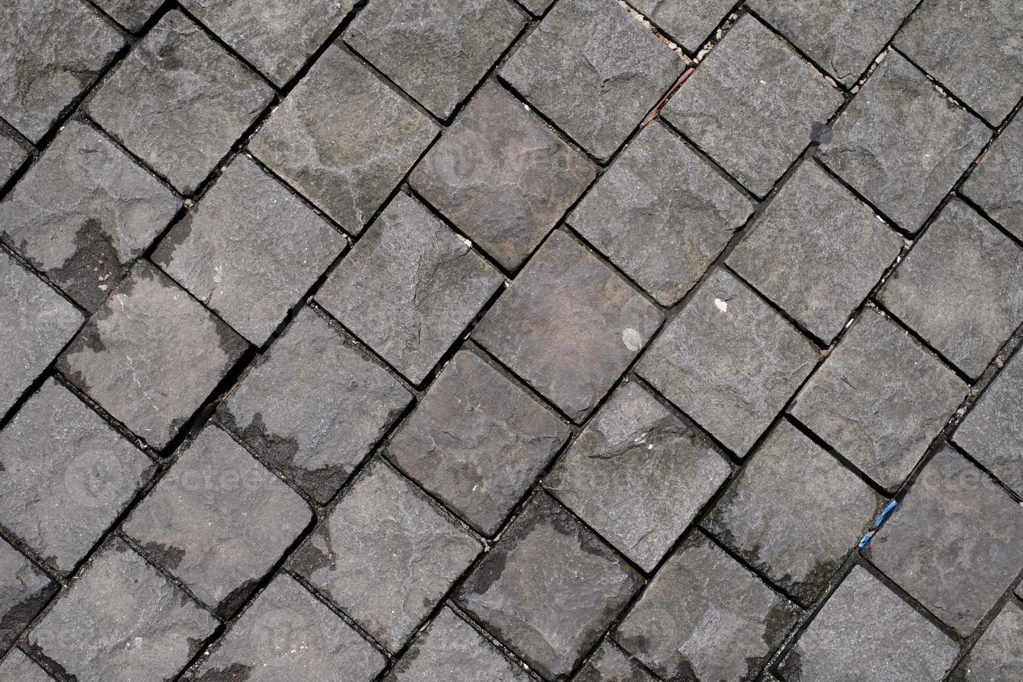 Black basalt paving which is wet because of the rain photo