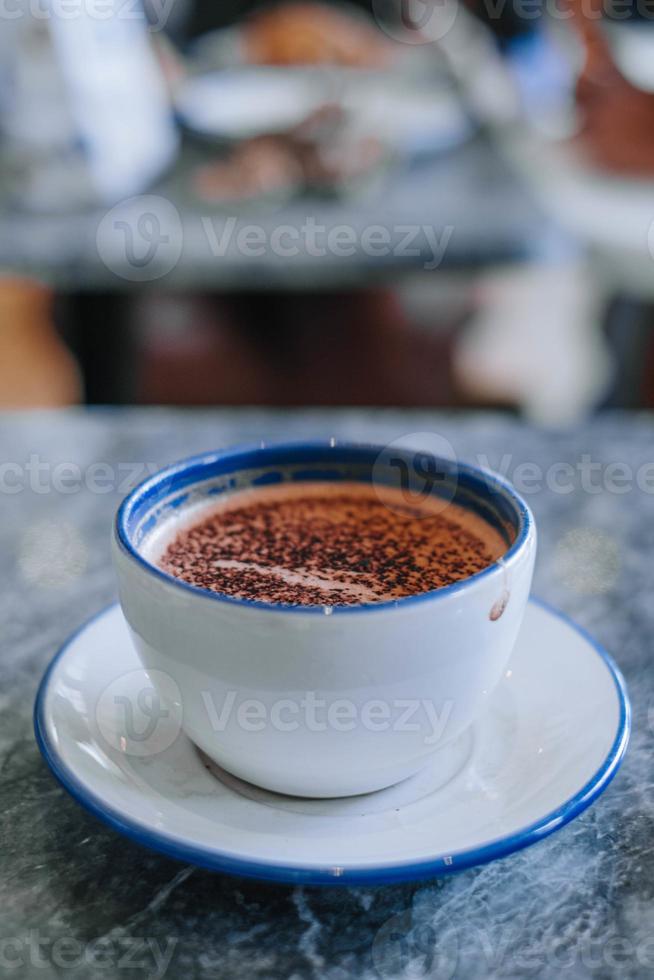 Steaming Hot Cappuccino in a White Ceramic Mug with Bokeh Background photo
