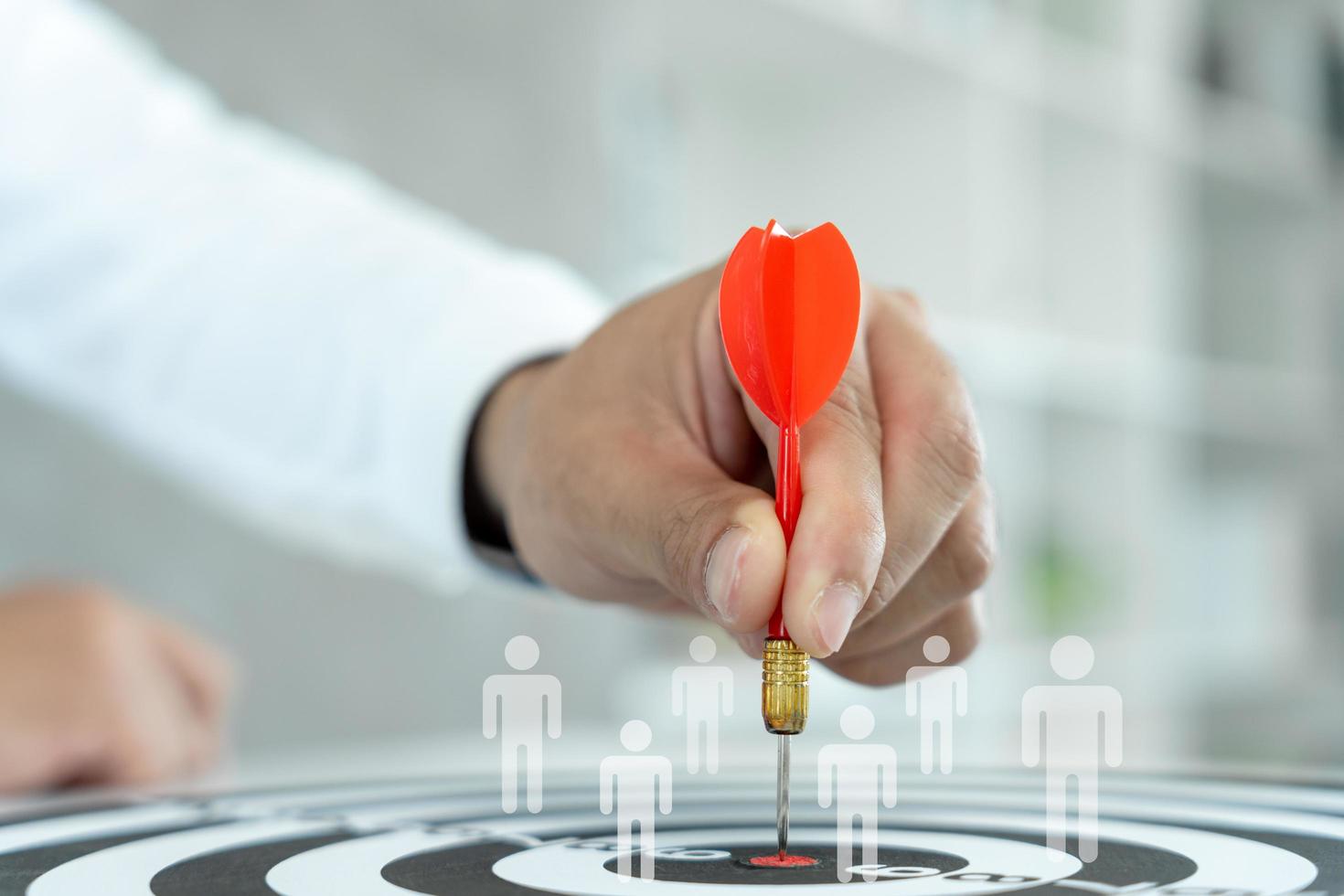 Businessman set goals for work. Hand holding a dart aiming at the target center business. goal, aiming marketing target metaphor, Succeed dart board, defines objectives, success investment ideas. photo