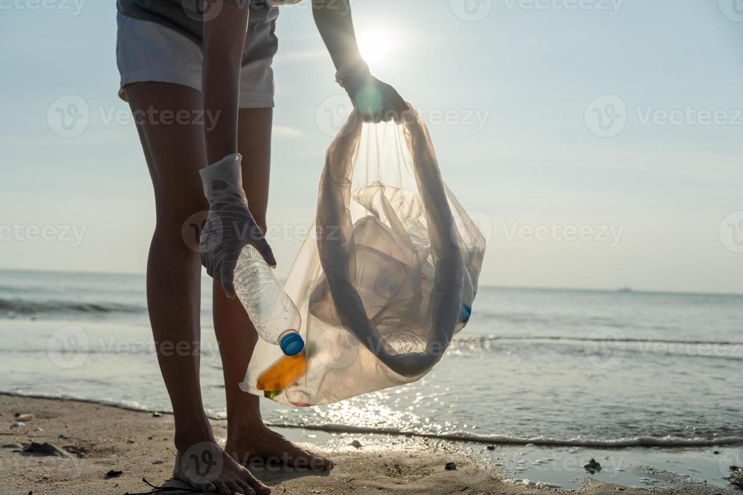 ahorrar agua. los voluntarios recogen basura en la playa y las botellas de plástico son difíciles de descomponer para evitar dañar la vida acuática. tierra, ambiente, planeta verde, reducir el calentamiento global, salvar el mundo foto