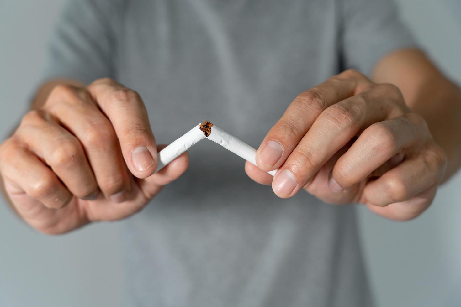 No Fumar. el hombre deja de fumar, se niega, rechaza, rompe el cigarrillo, dice que no. dejar de fumar por salud. día mundial del tabaco. drogas, cáncer de pulmón, enfisema, enfermedad pulmonar, narcótico, efecto nicotina foto