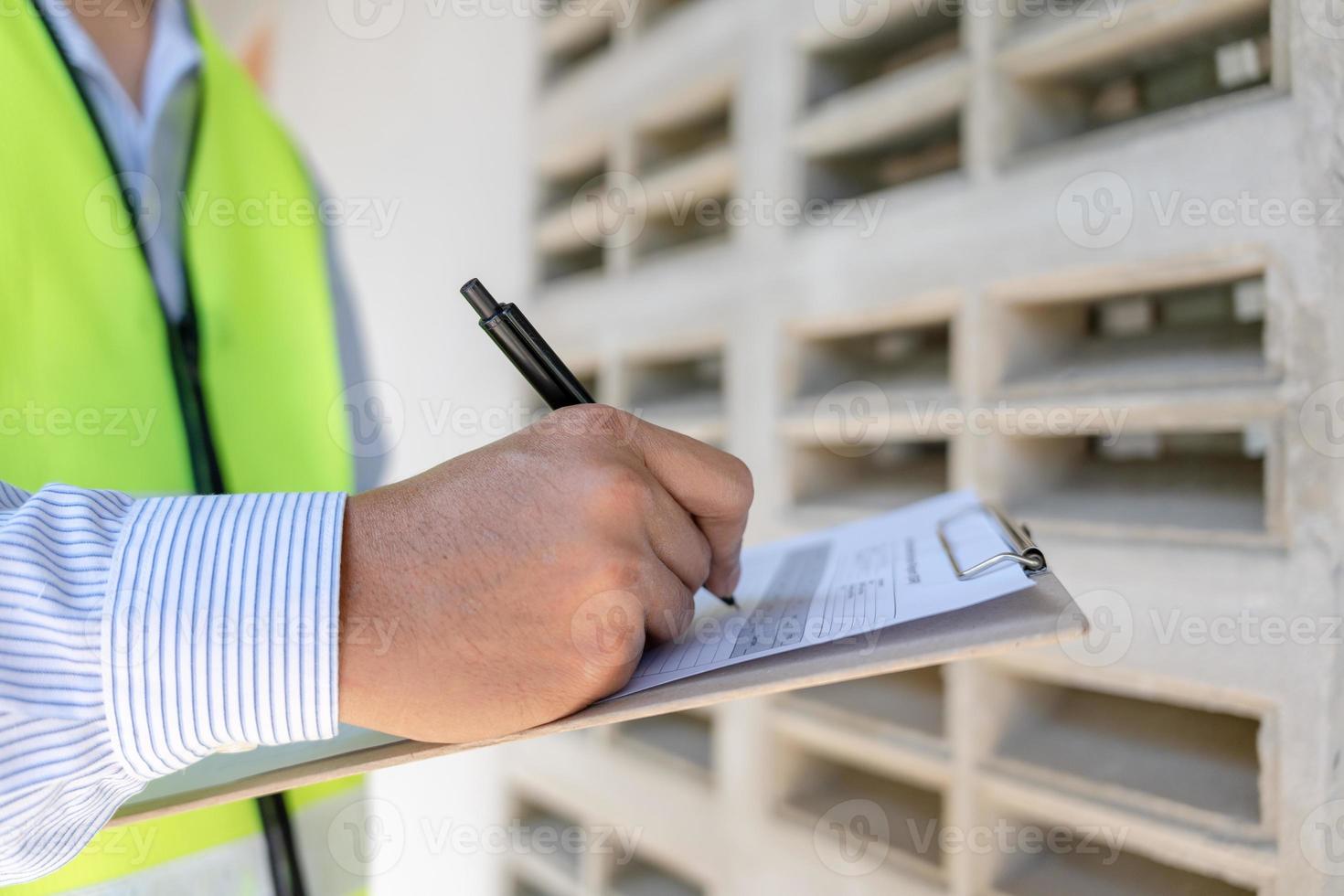 el inspector o ingeniero está inspeccionando la construcción y el aseguramiento de la calidad de la nueva casa usando una lista de verificación. ingenieros o arquitectos o contratistas trabajan para construir la casa antes de entregársela al propietario foto