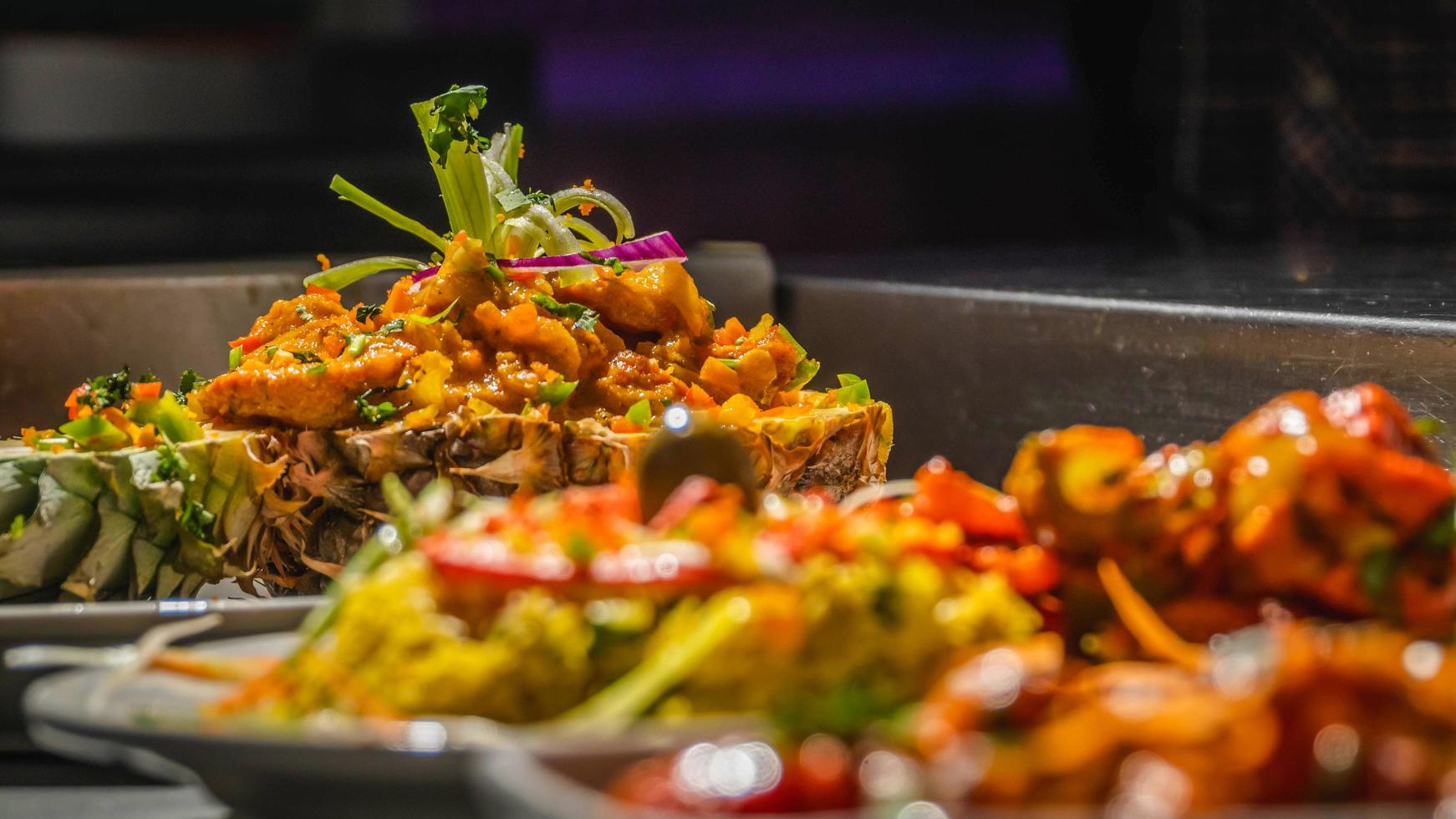 A table topped with lots of different types of food, colorful dramatic lighting, close up shot from the side. photo