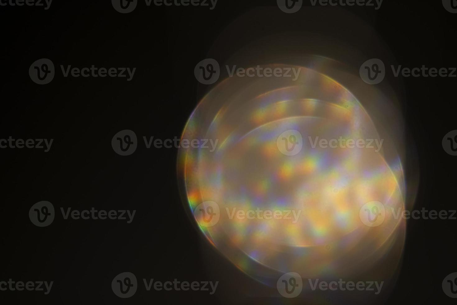 Glare effect on a black background. An abstract lens flare for on-screen use. Glare of the optical rays of the lens. photo