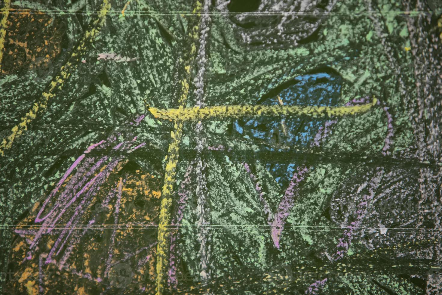Drawings of children with chalk on a school green board. photo