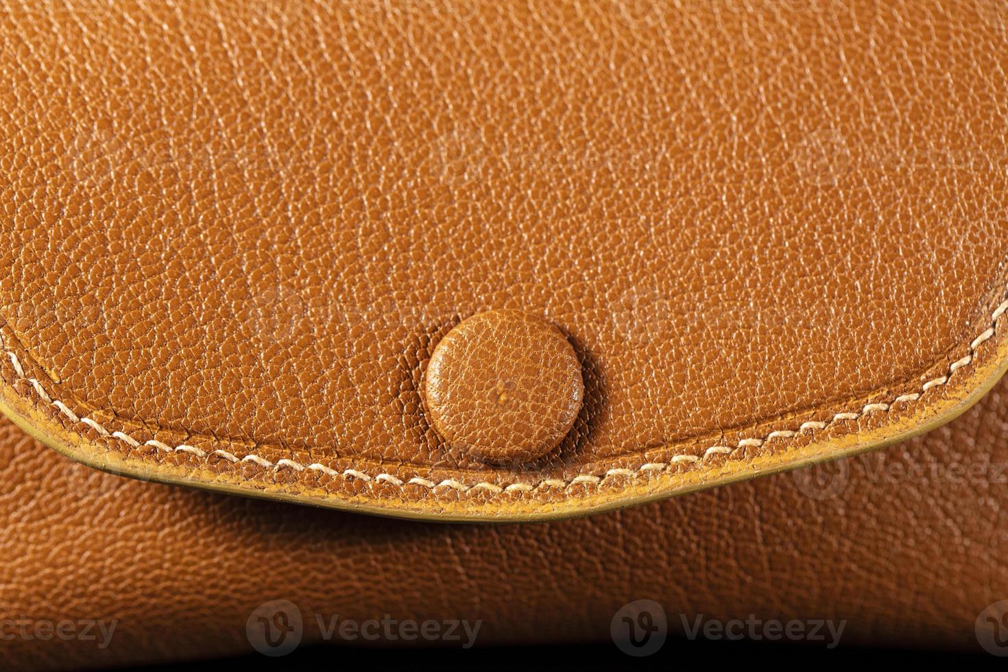 Part of a brown leather wallet or case with stitching. photo