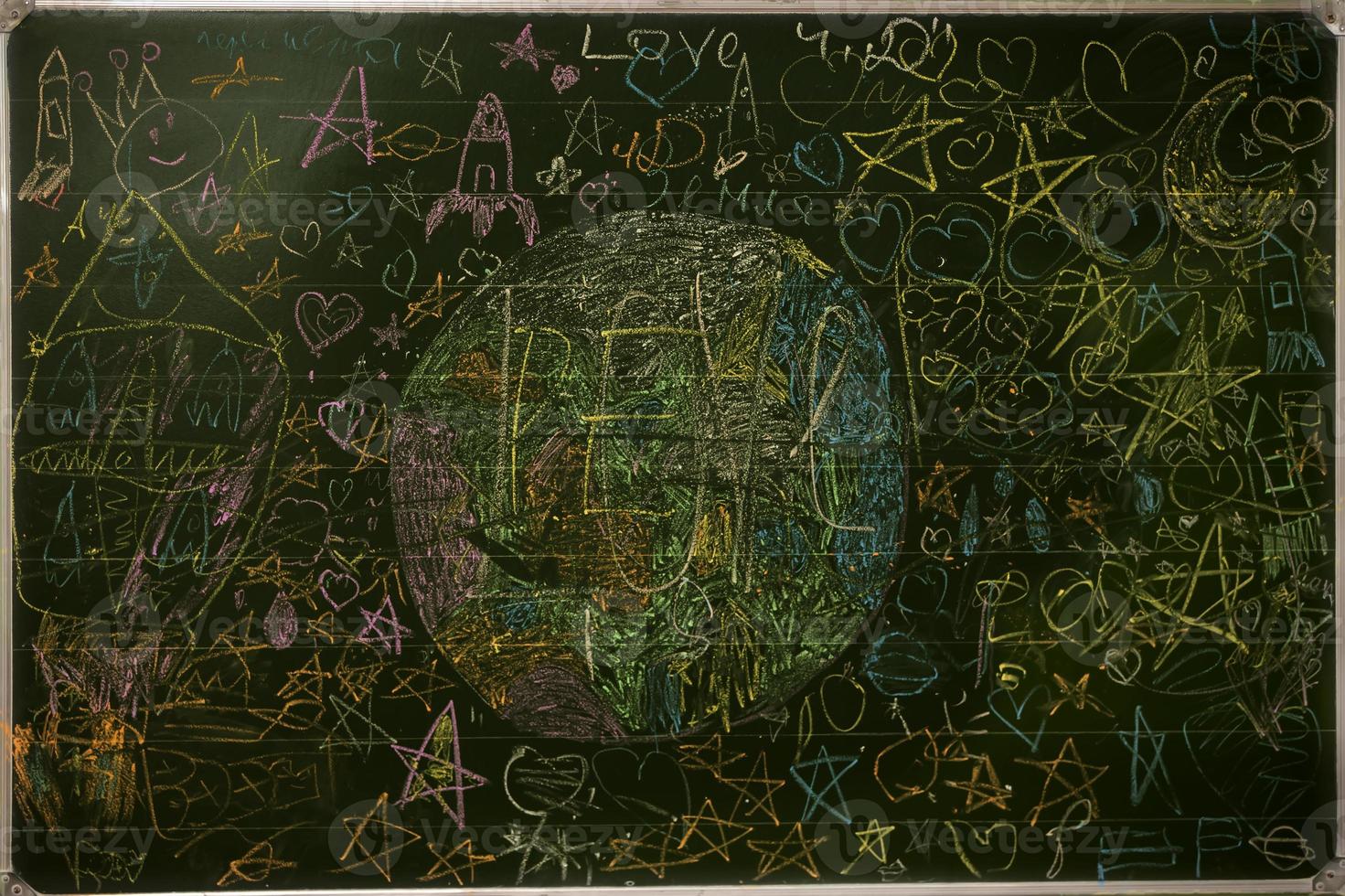 Drawings of children with chalk on a school green board. photo