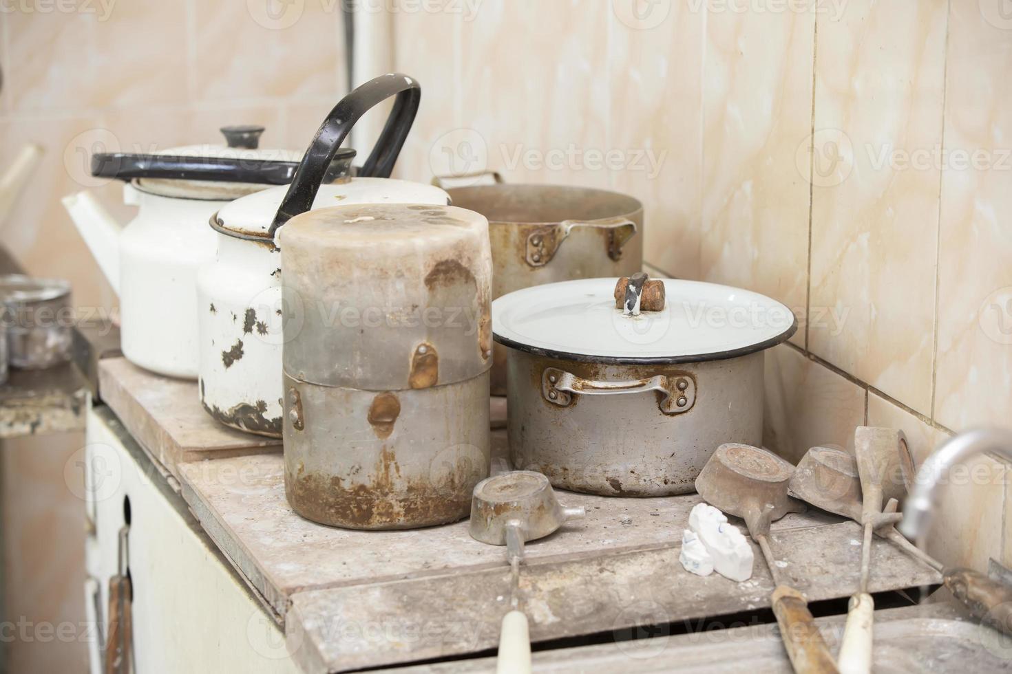 Old dirty rusty crockery pots and kettles. photo