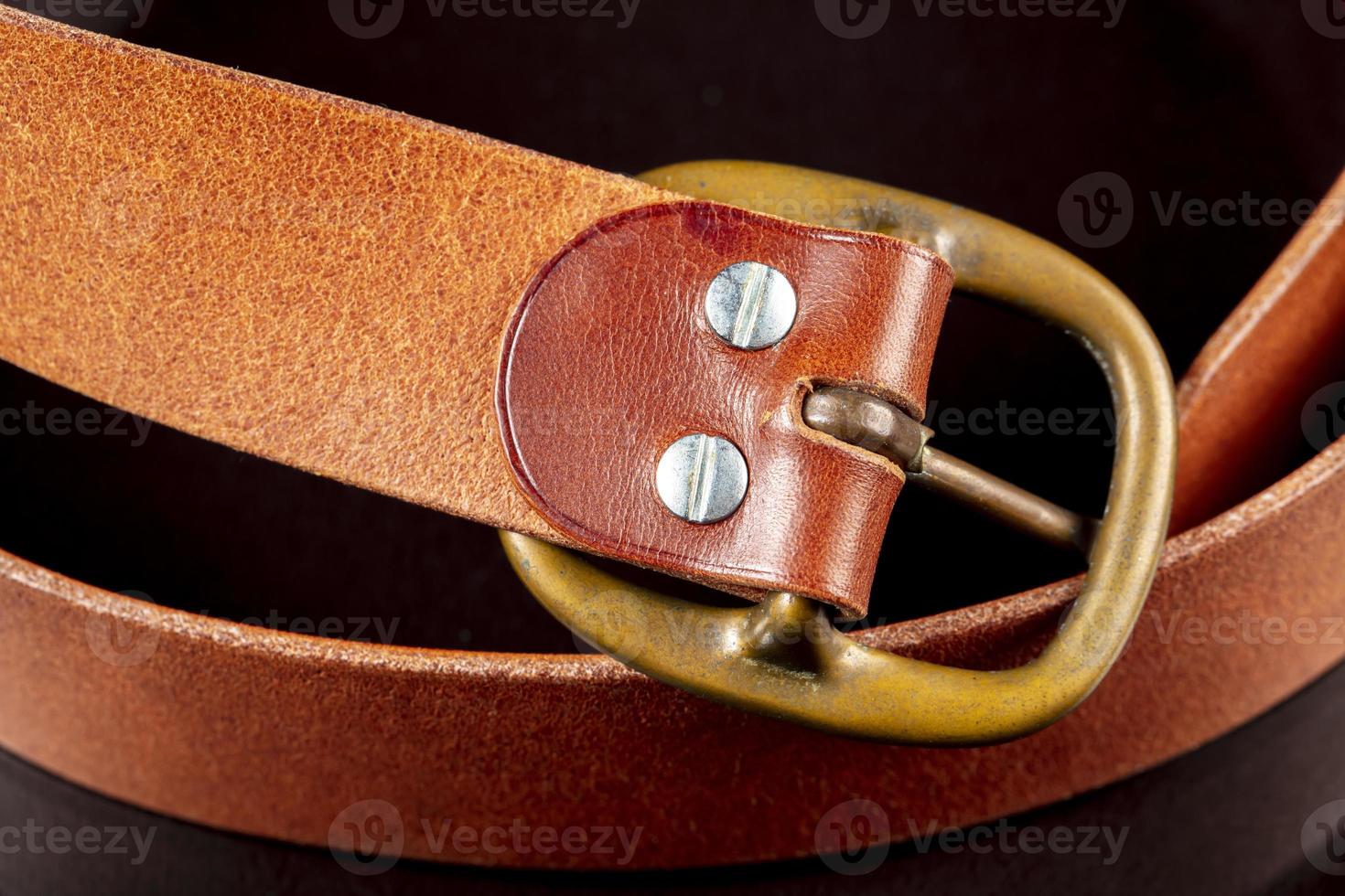 Part of a leather belt on a dark background. photo