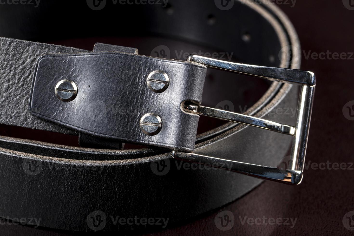 Black leather belt on a dark background. Leather products. photo