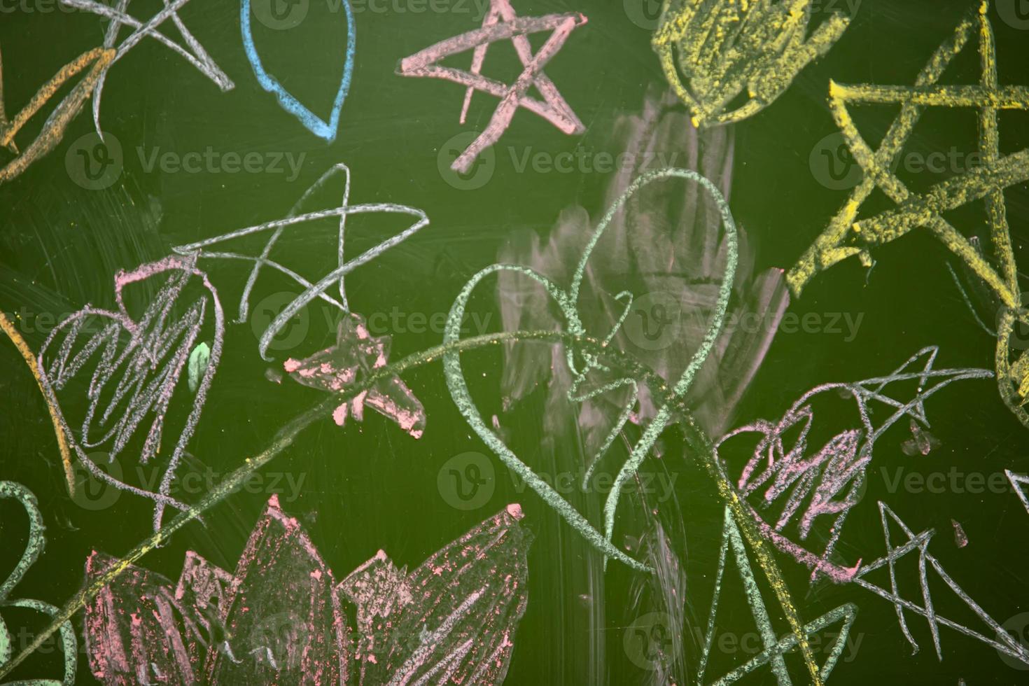 Drawings of children with chalk on a school green board. photo