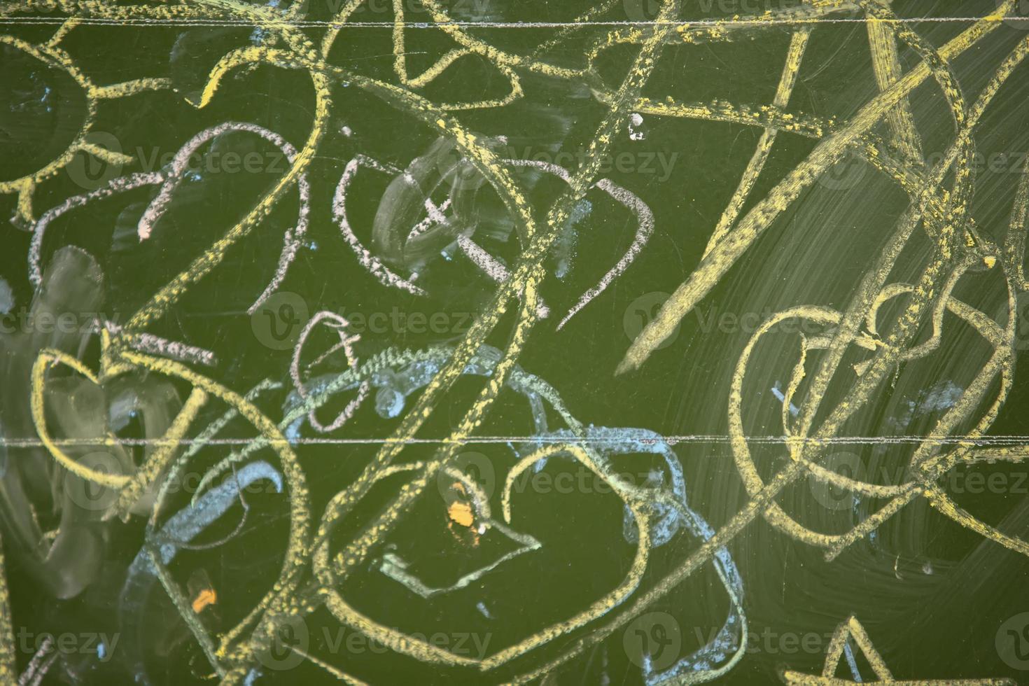 Drawings of children with chalk on a school green board. photo