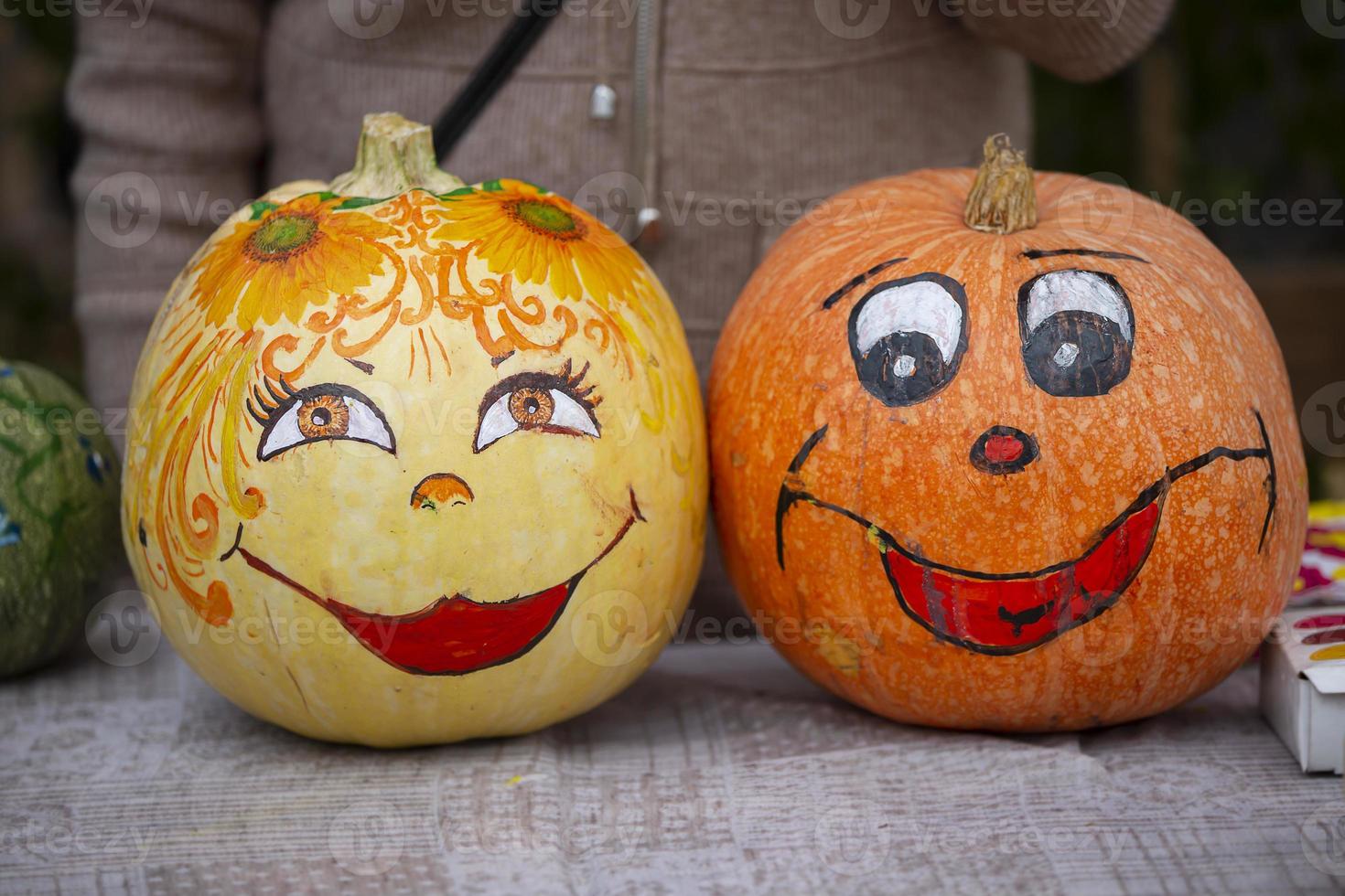 un creativo Víspera de Todos los Santos calabaza con un tipo y linda modelo. mal calabaza. foto