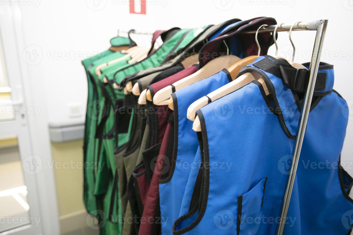 Rack of lead aprons used for x-ray protection in operating room, hospital photo