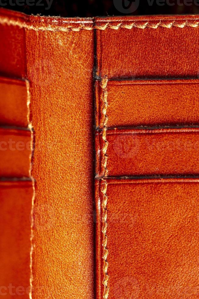 Part of a brown leather wallet or case with stitching. photo