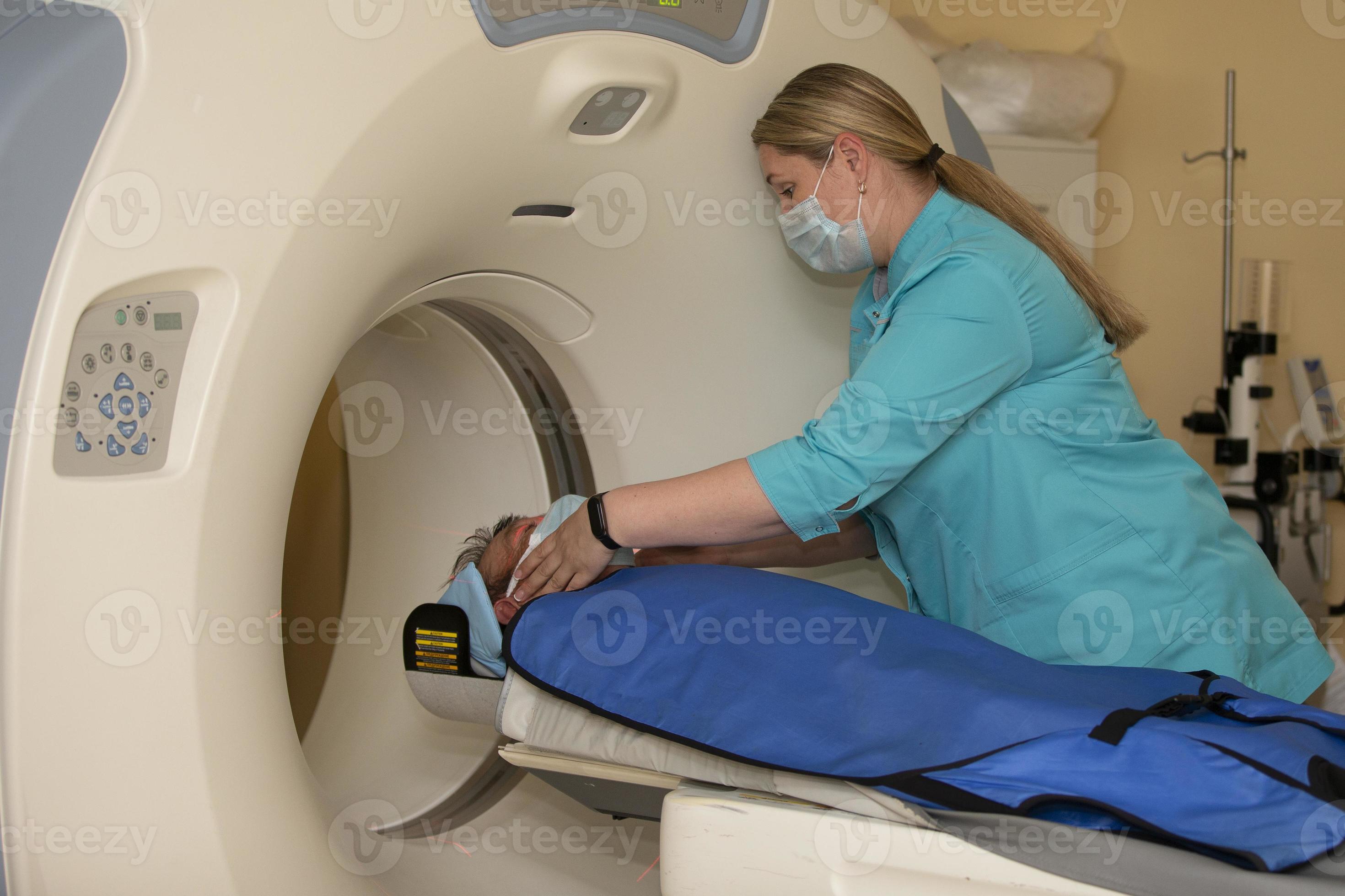 A doctor in a medical gown prepares a patient for resonance