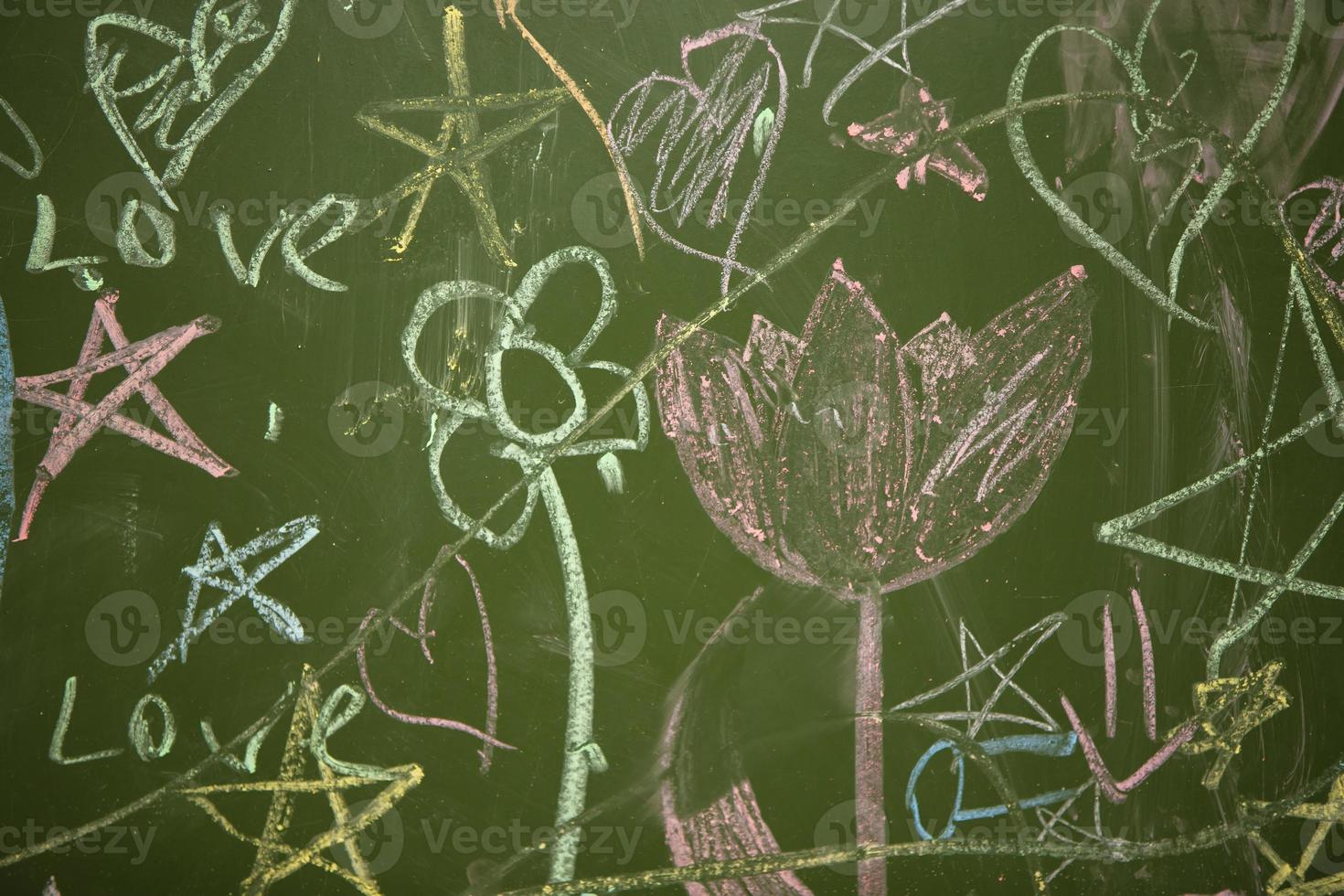 Drawings of children with chalk on a school green board. photo