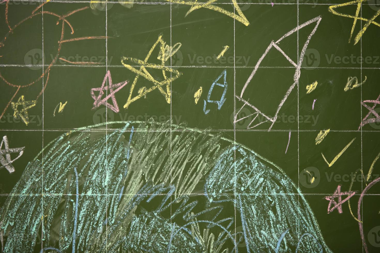 Drawings of children with chalk on a school green board. photo