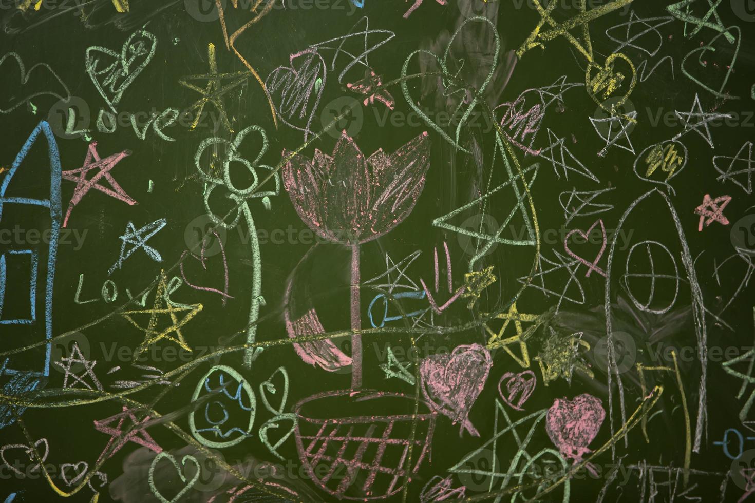 Drawings of children with chalk on a school green board. photo