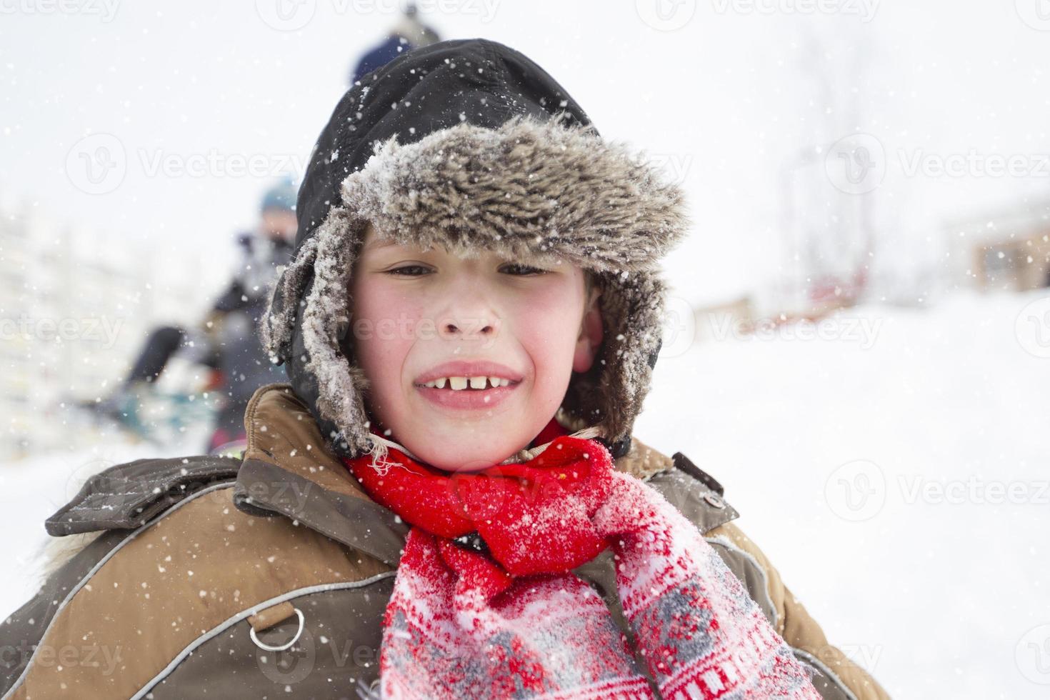 Funny boy in a hat with earflaps on a winter day. Child in winter close-up. photo