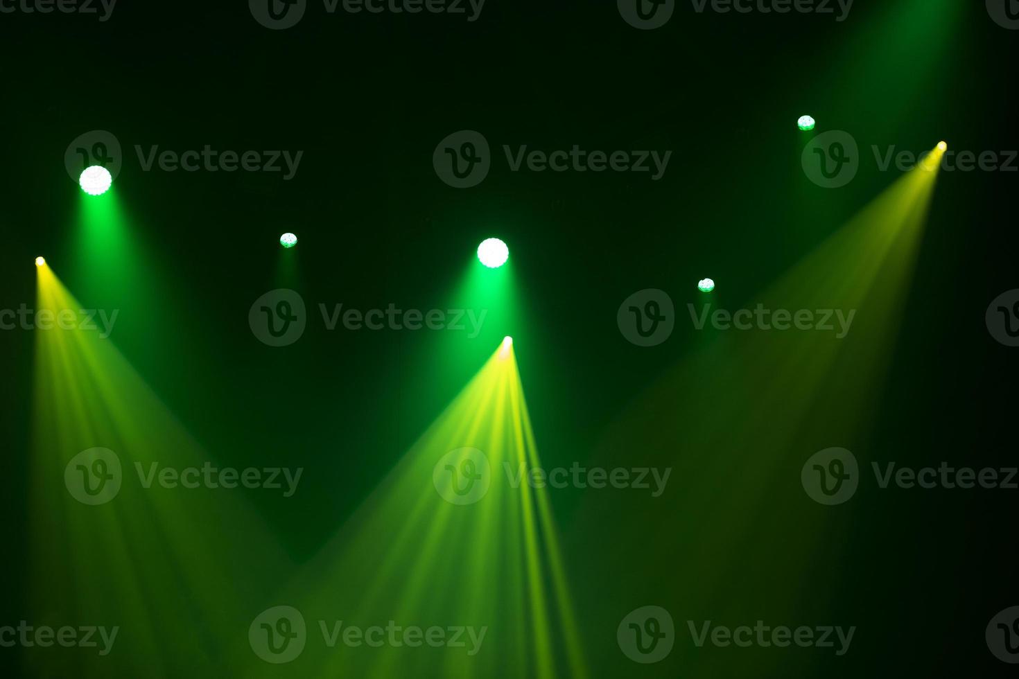 Green stage light from spotlights on a dark background. photo