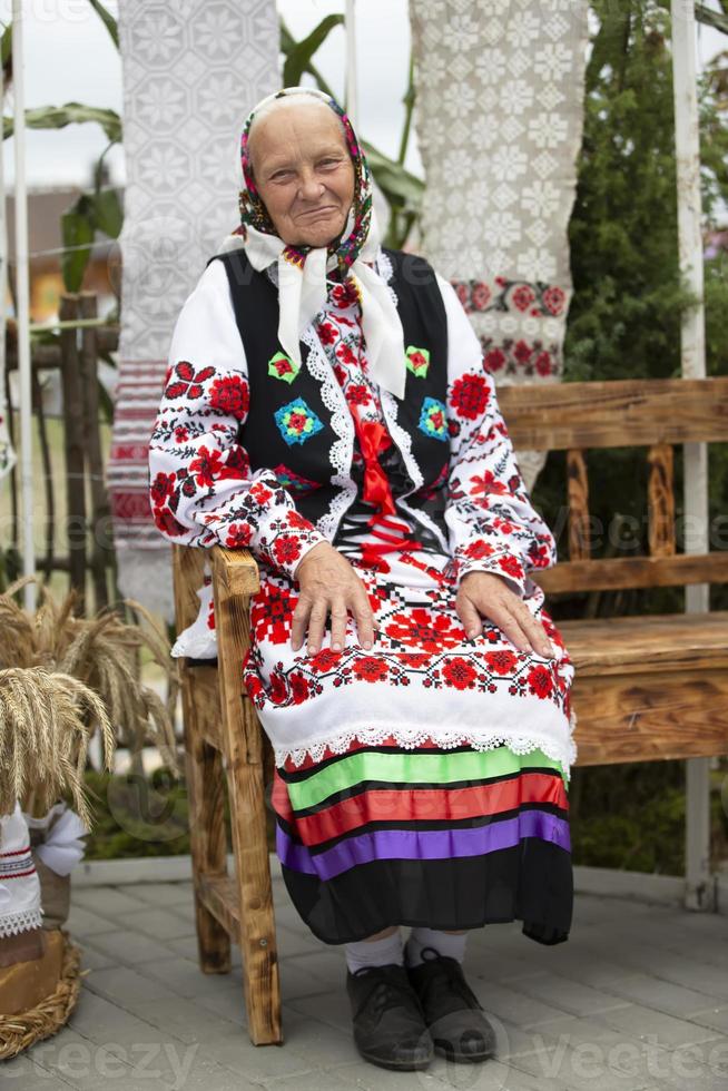 An old Belarusian or Ukrainian woman in an embroidered shirt. Slavic elderly woman in national ethnic clothes. photo