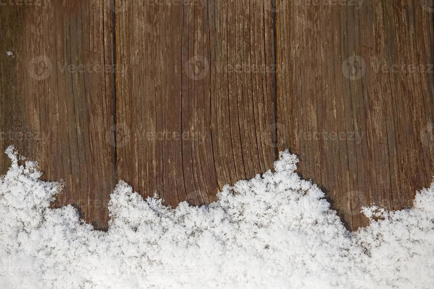 Snow on a wooden background. Winter background with board and snowflakes. photo