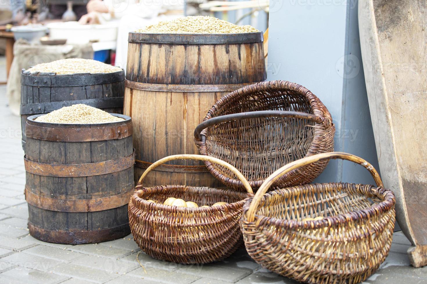 Autumn harvest at the fair. Wooden barrels with grain and wicker baskets with potatoes. photo