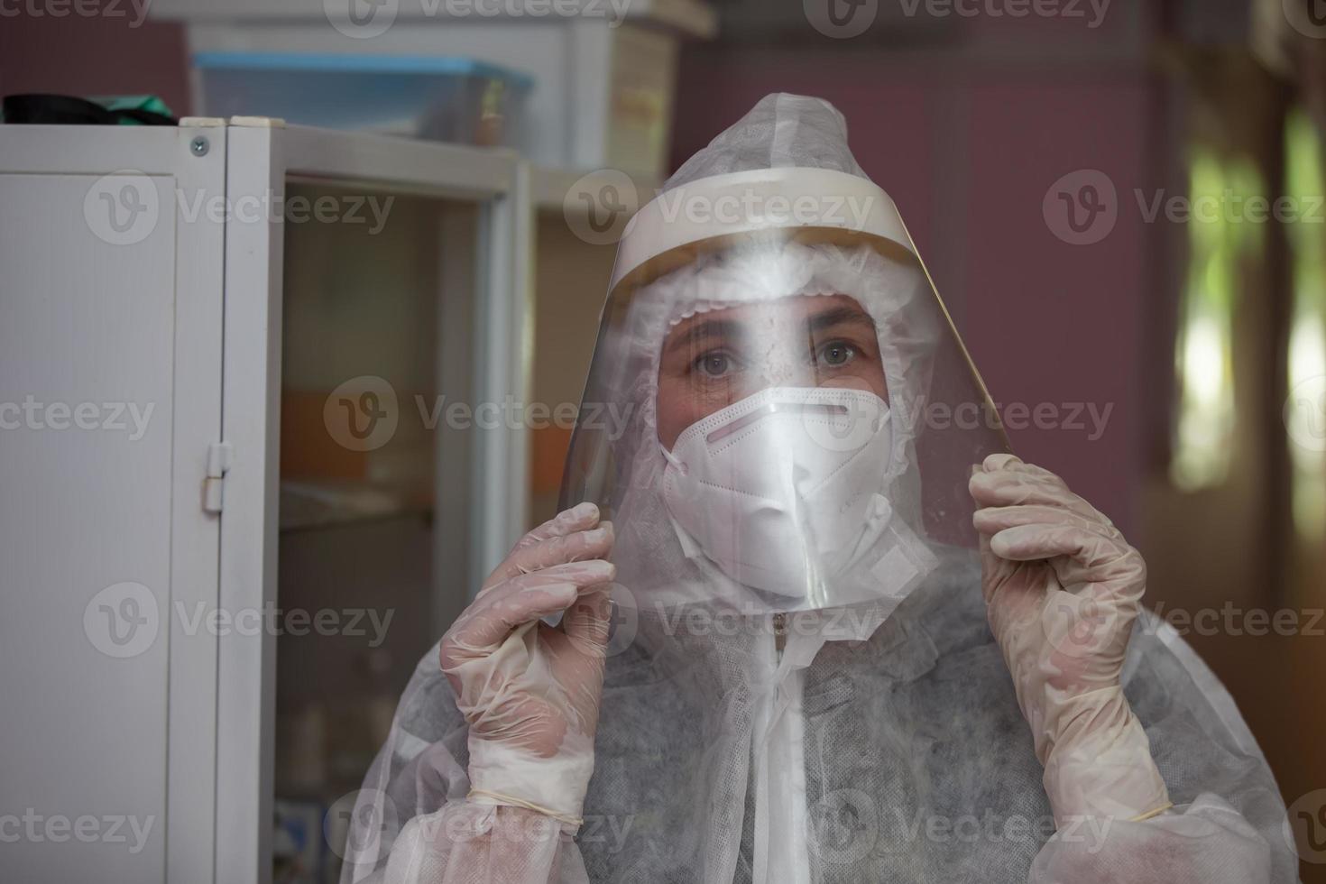 The face of a female doctor close-up in a protective suit. photo