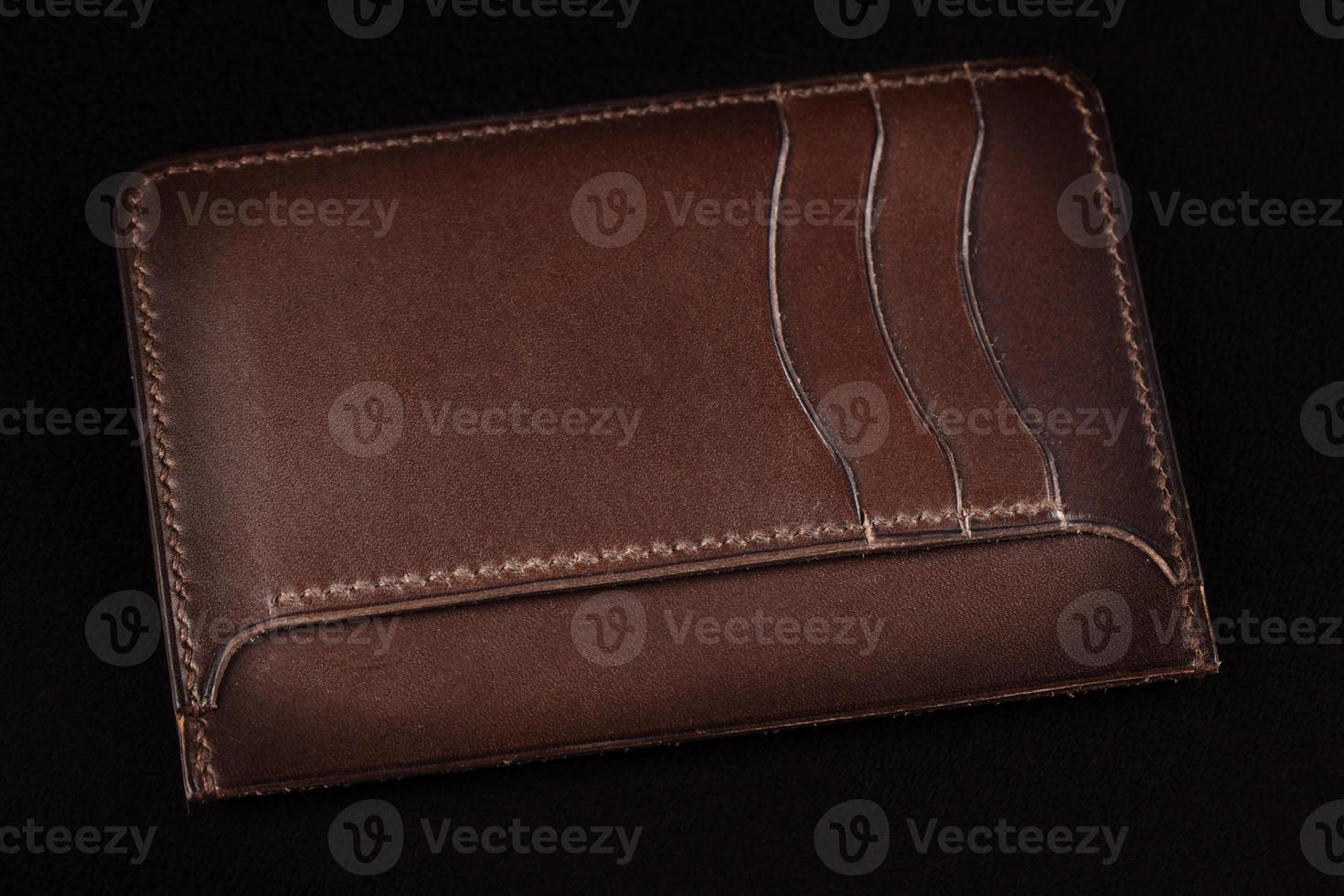 Brown leather wallet on a dark background. photo