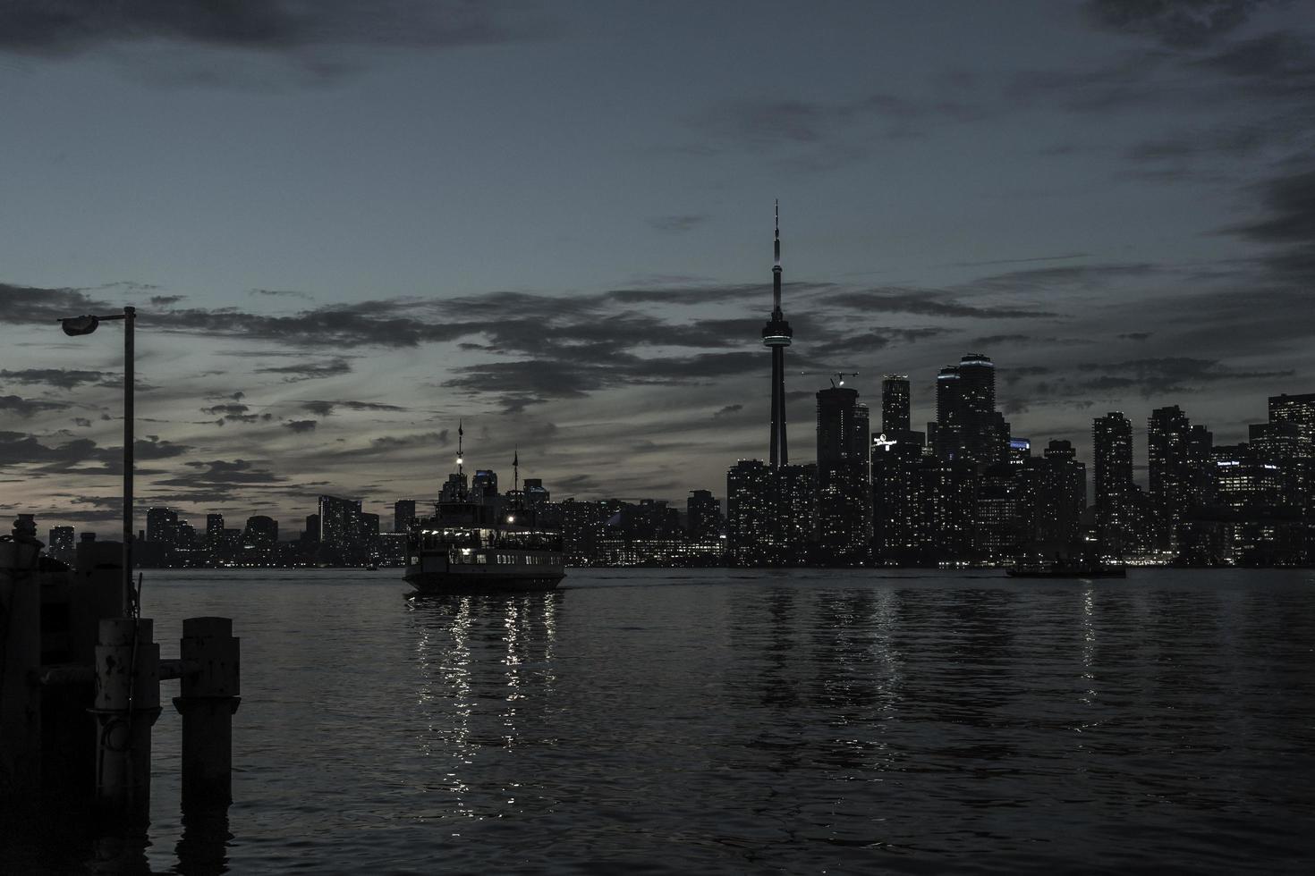 The Toronto shoreline at late sunset with a passenger ferry crossing between Centre Island and Toronto. photo