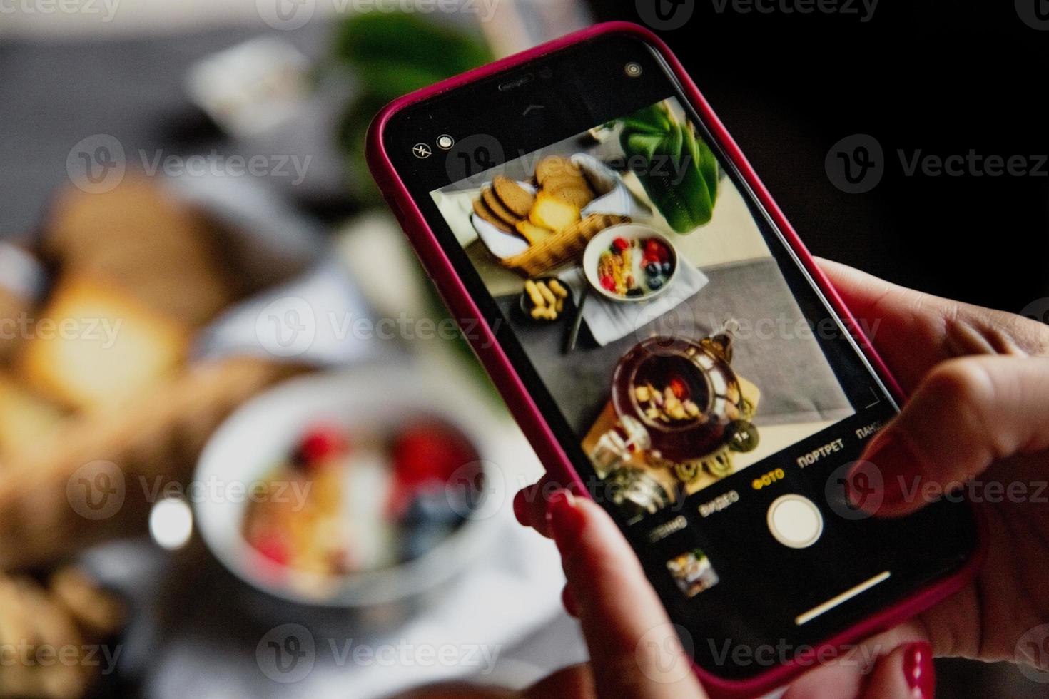 breakfast set, oatmeal with berries and yogurt, black tea with roses, bread, photo on the phone