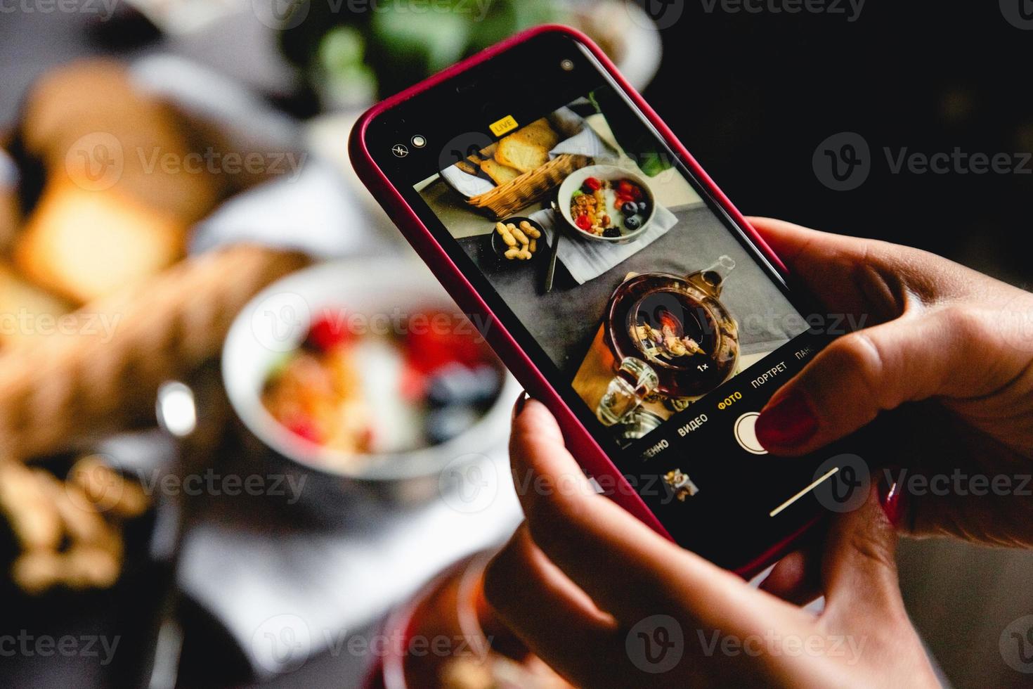 breakfast set, oatmeal with berries and yogurt, black tea with roses, bread, photo on the phone