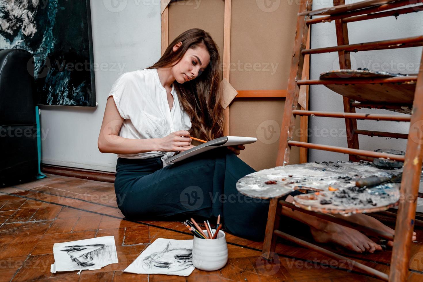 portrait of a beautiful young artist, draws pictures in the workshop photo