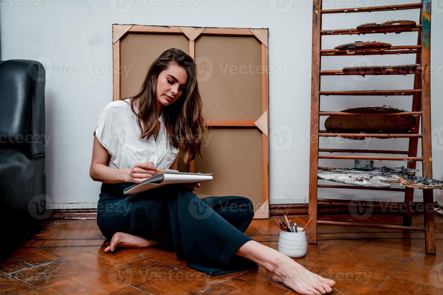 portrait of a beautiful young artist, draws pictures in the workshop photo