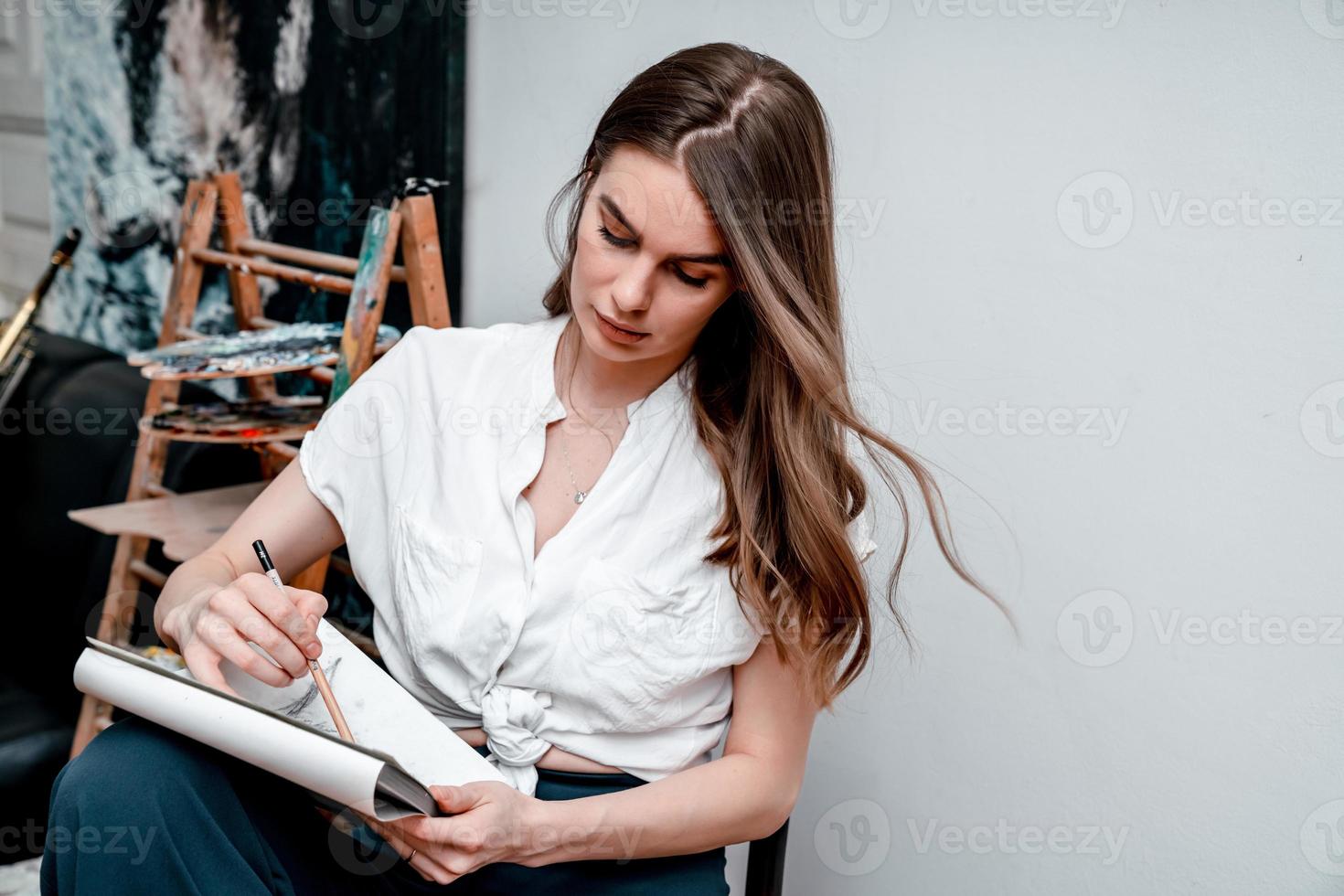 the artist is working on a painting draws a sketch in the workshop photo