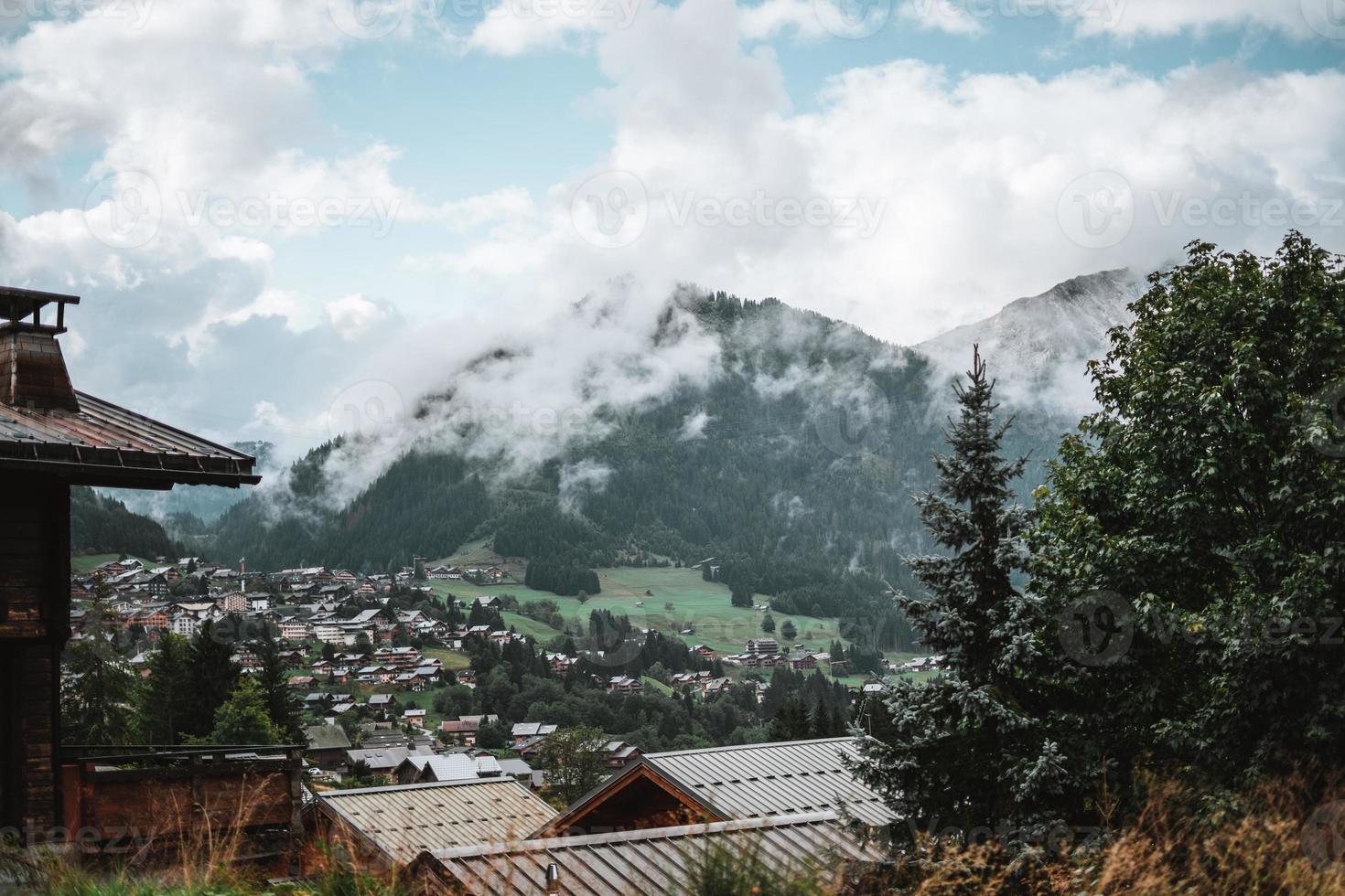 Majestic mountains in the Alps covered with trees and clouds photo