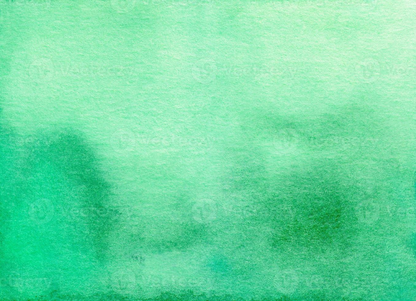 Watercolor calm green ombre background texture. Stains on paper photo